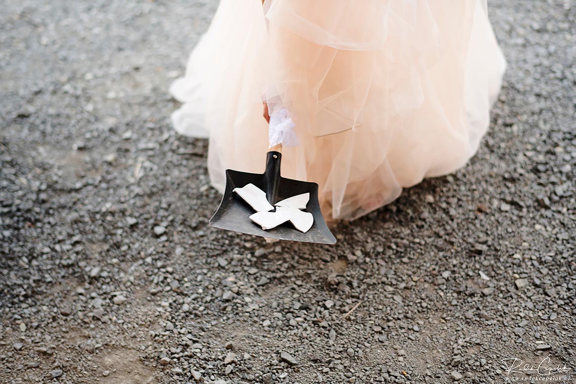 bride holding dustpan with shards
