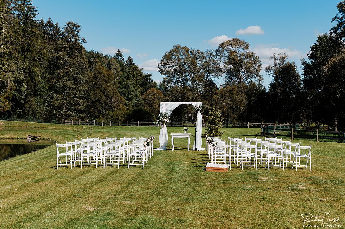 white chairs on outside wedding ceremony