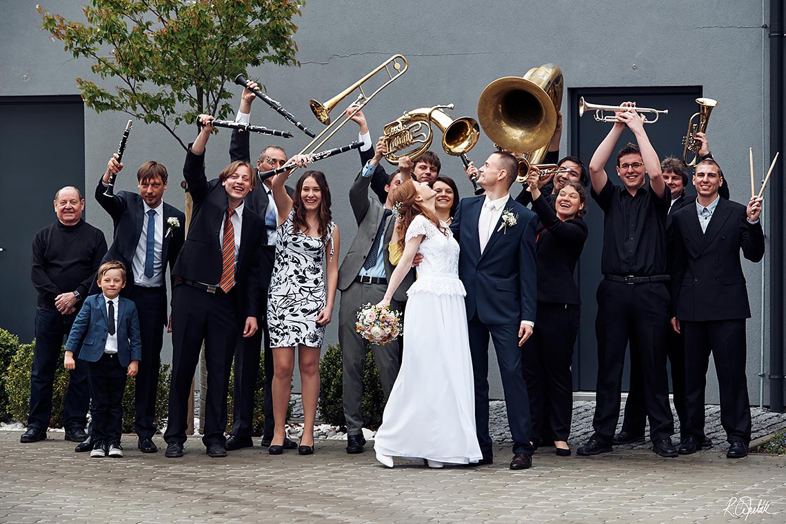 group photo of bride and groom with breathing orchestra
