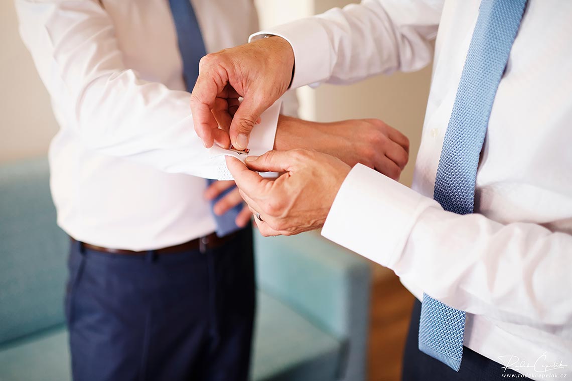 buttoning cufflinks during getting ready of groom