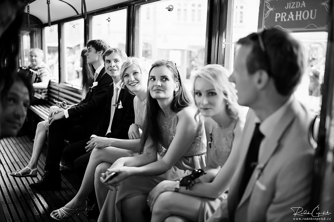 wedding guests during ride with historical tram in Prague