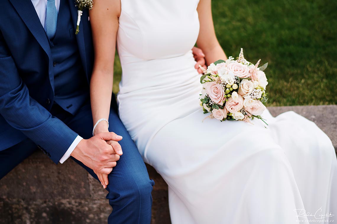 bride and groom holding their hands while sitting