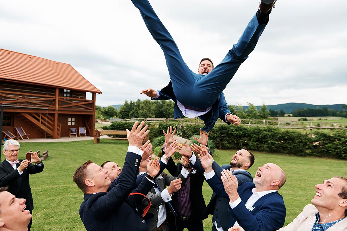 Wedding photography of groom flying in the air.