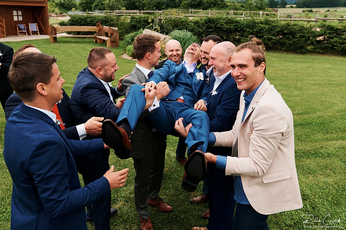 Groom is having fun with friends after ceremony at wedding