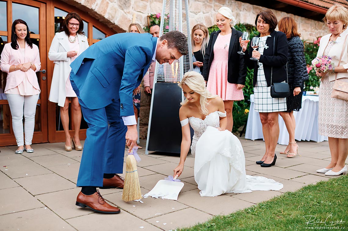 Wedding photo of cleaing shards from broken plate