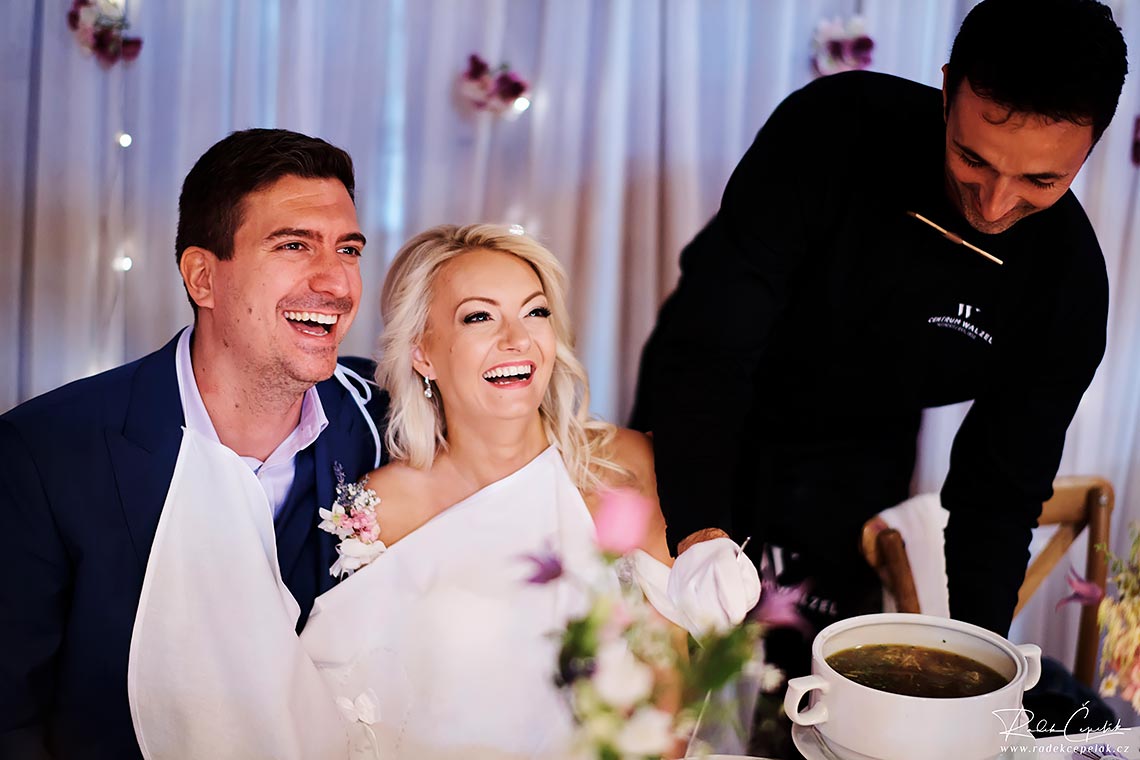 Bride and groom laughing at wedding reception in barn wedding