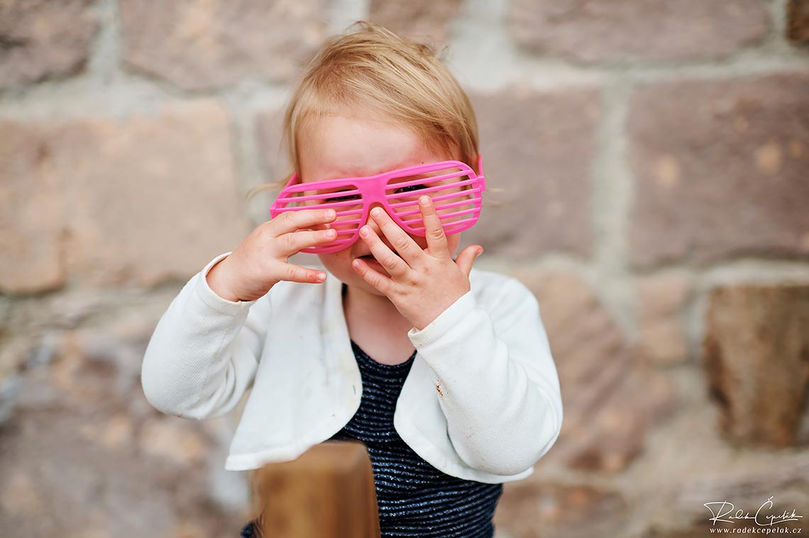 Pink glasses on small child at wedding
