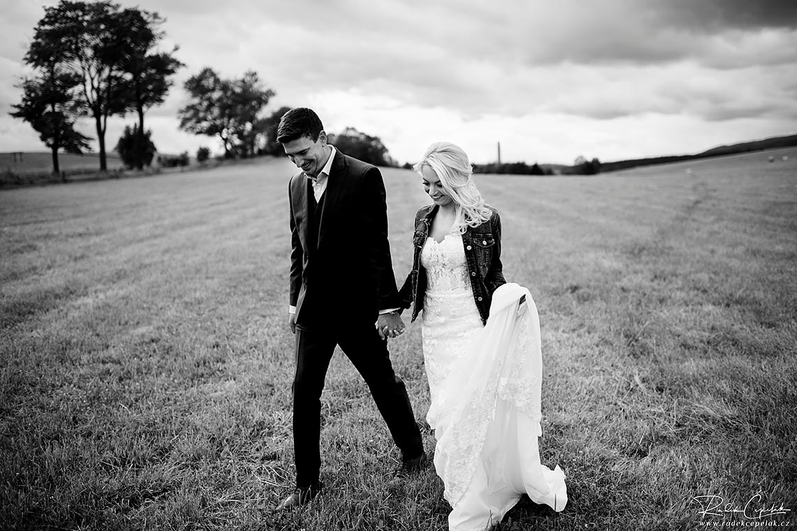 Black and white wedding photo of walking bride and groom