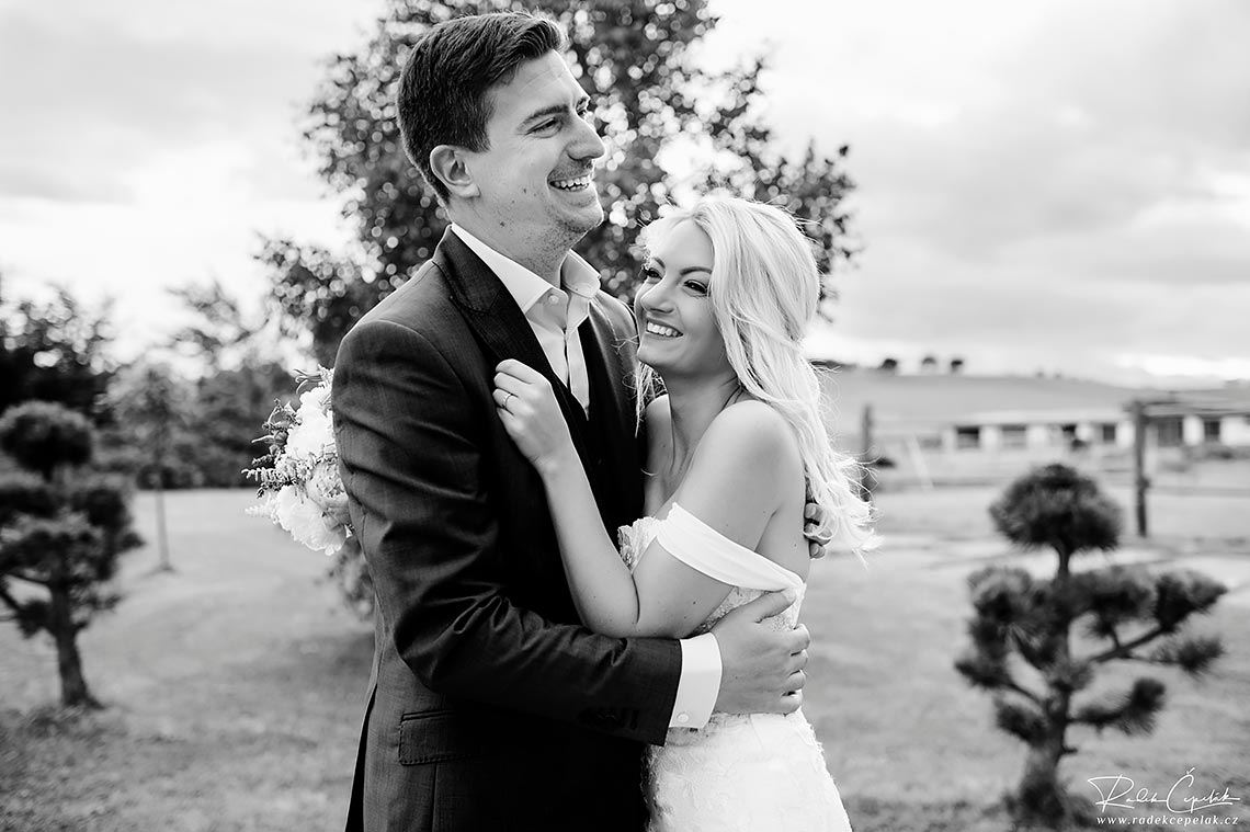 wedding photography of hugging bride by groom