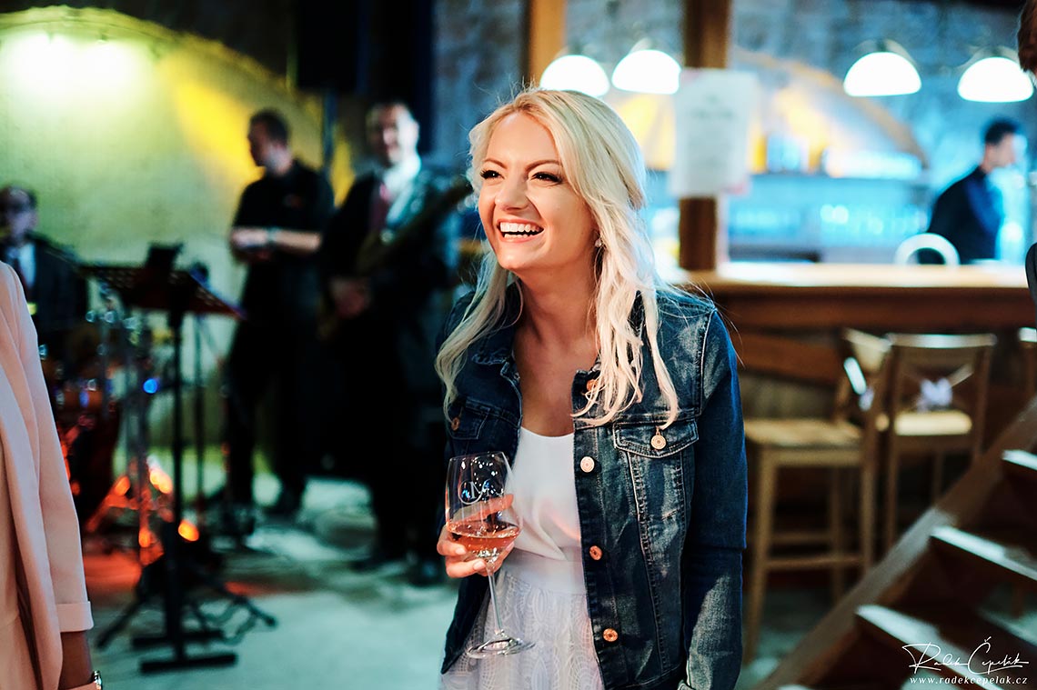 Bride with jeans jacket with glass of wine on wedding party
