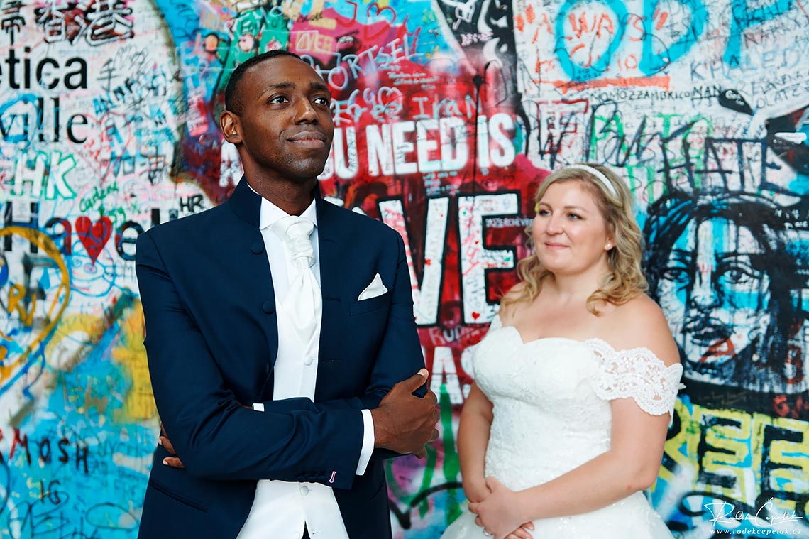 groom wedding photography in front of Lennon wall