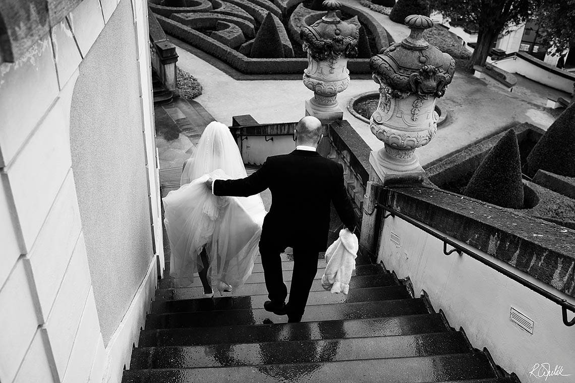 groom helping bride with wedding dress trail
