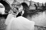 black and white wedding photography of smiling couple in front of Charles bridge in Prague