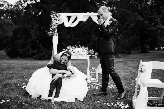 Touching wedding photography of bride and groom with their child