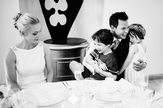 wedding photo of bride and groom with children during wedding reception